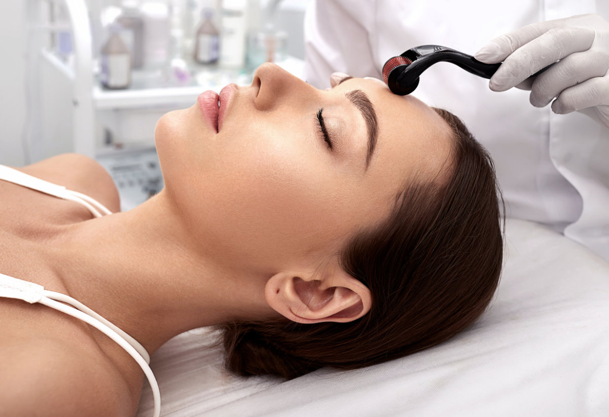 Beautician Doing Skin Treatment Using A Microneedle Dermaroller.