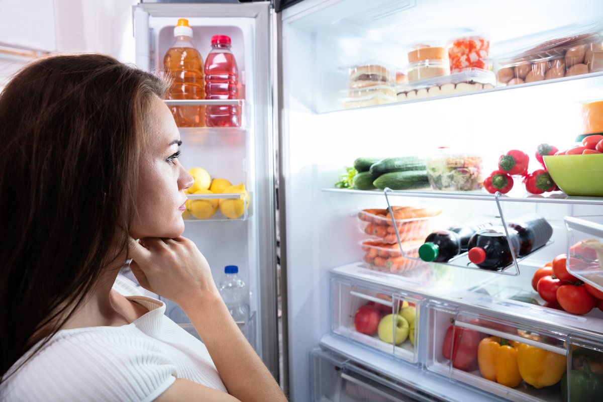 woman looking for food in refrigerator