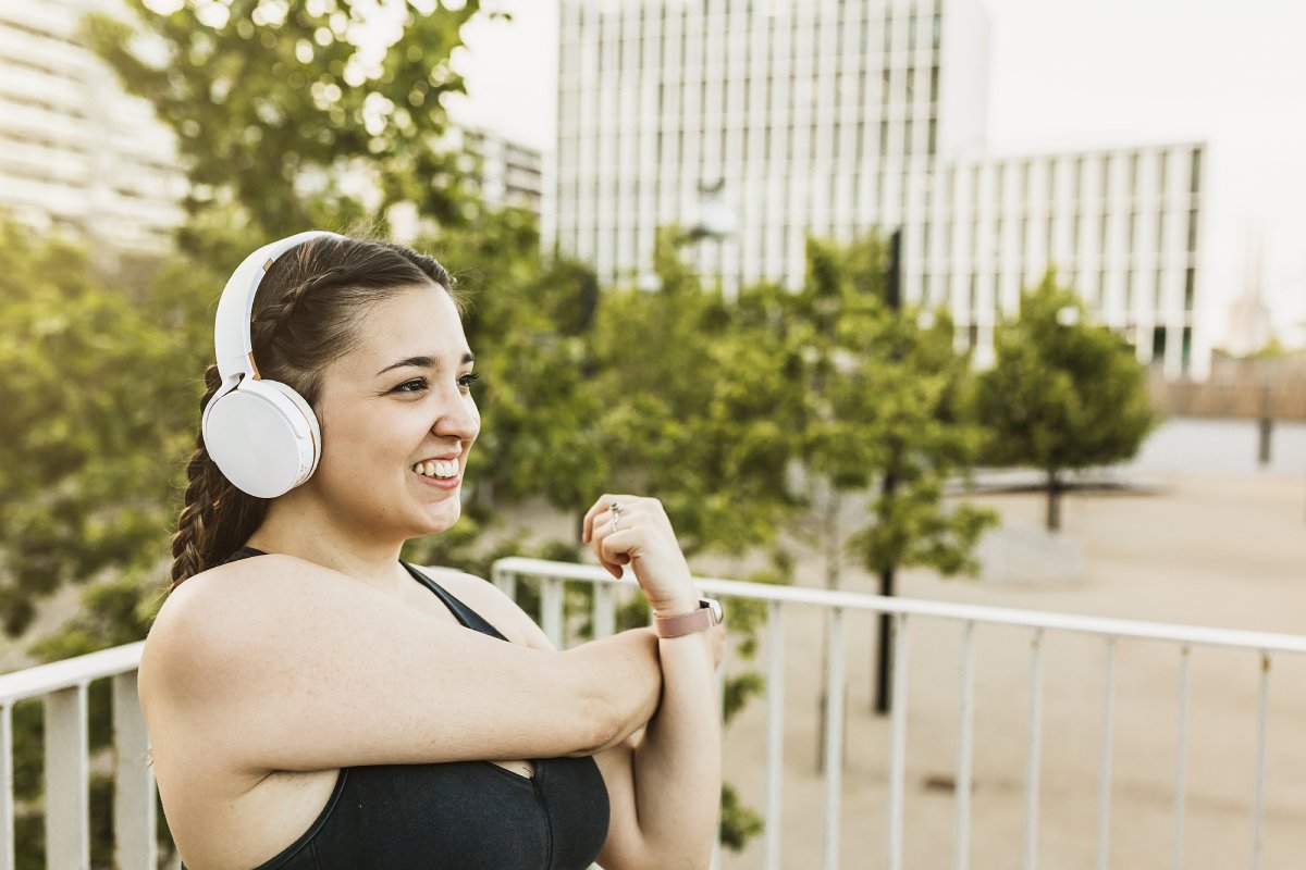 smiling young woman stretching while listening music