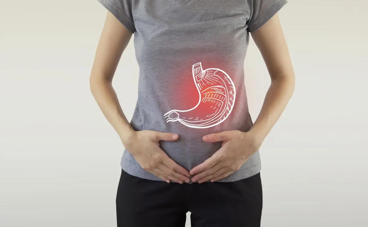 Person holding stomach area with a digital illustration of a stomach organ and a red glow, indicating abdominal pain or digestive issues.