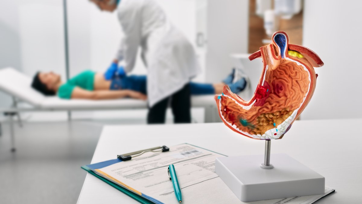 Gastroenterologist consultation, treatment of stomach diseases. Doctor palpates woman patient abdomen and examines belly at clinic